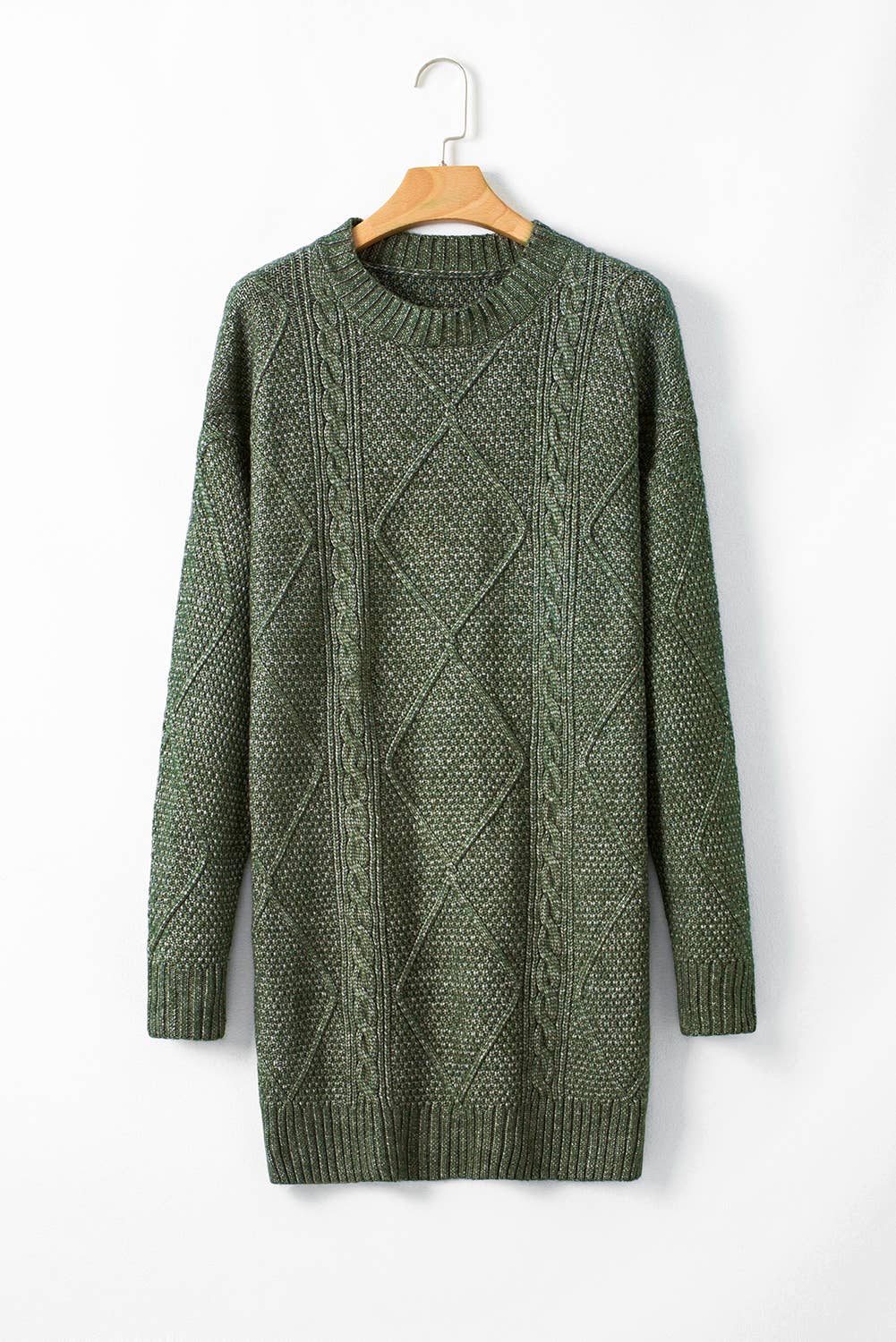 Green cable knit sweater on a wooden hanger against a white background