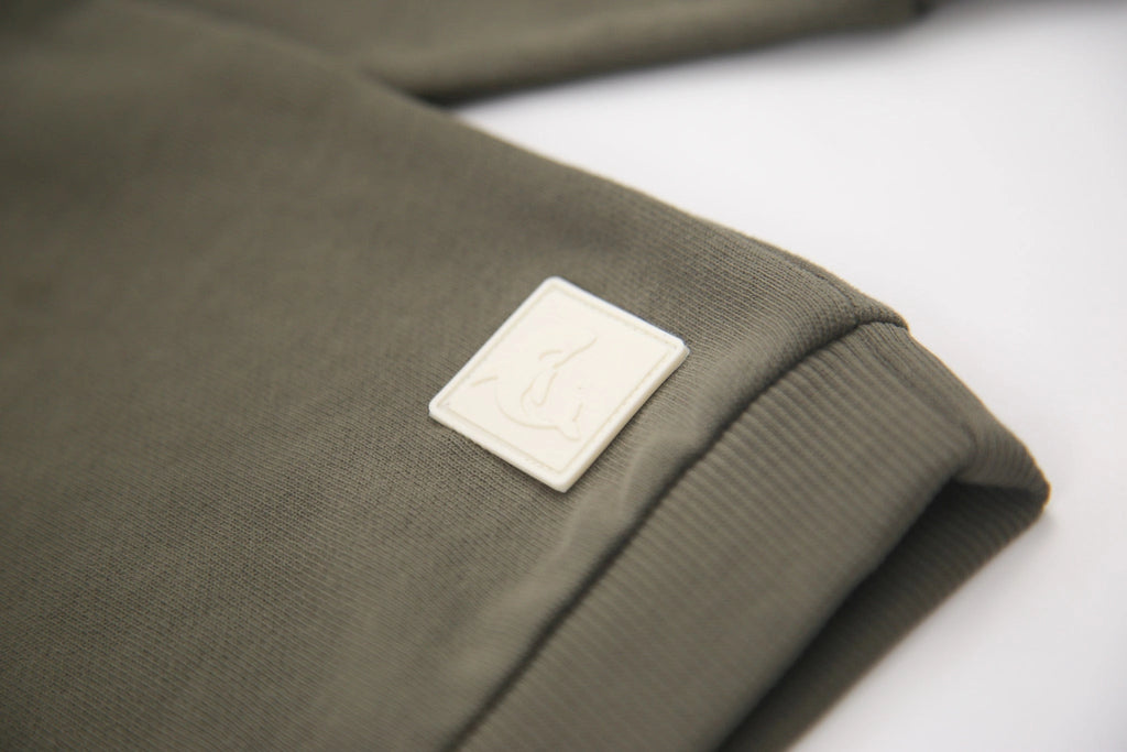 Green fabric with a white logo patch on a white background