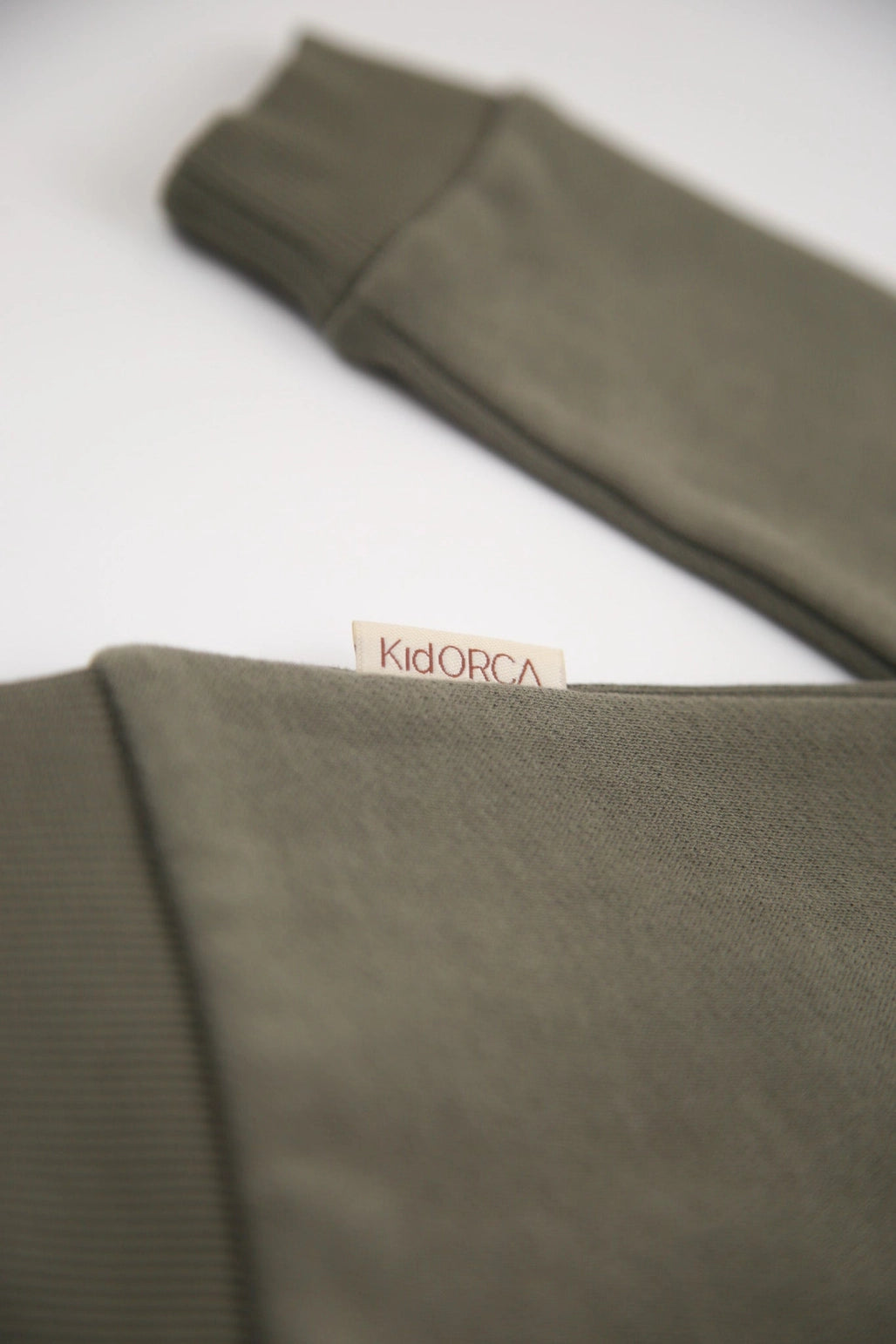 Green fabric with a visible brand label on a white background