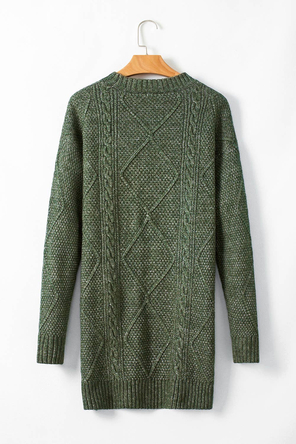 Green cable knit sweater on a hanger against a white background