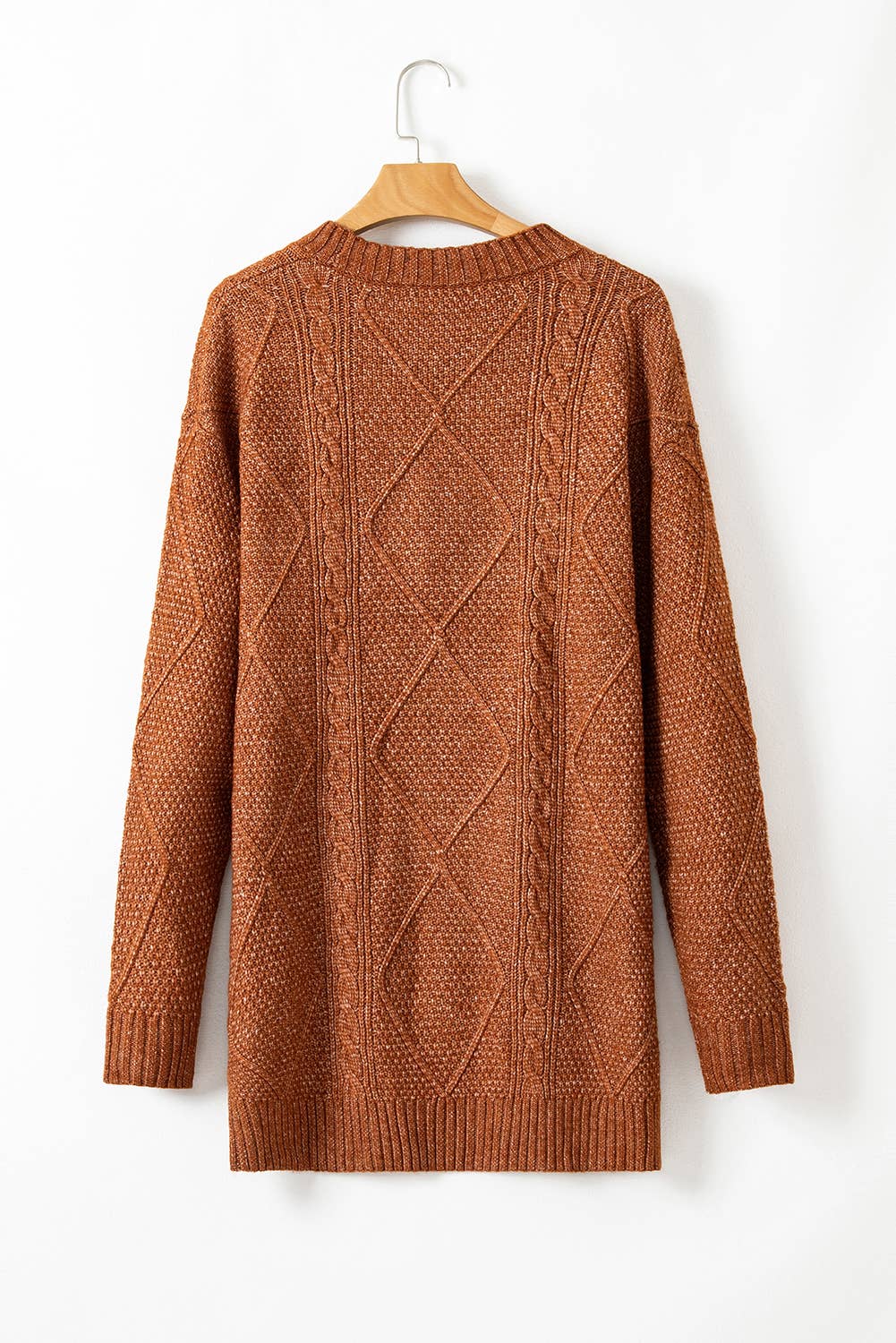 Brown cable knit sweater on a hanger against a white background