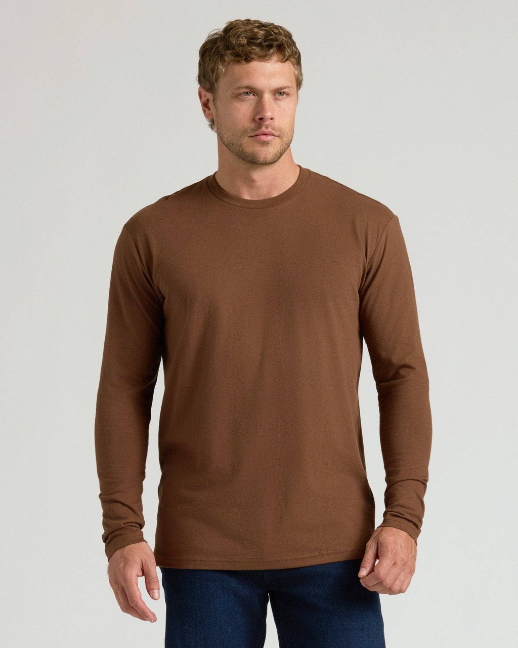 Man wearing a brown long-sleeve shirt against a light gray background
