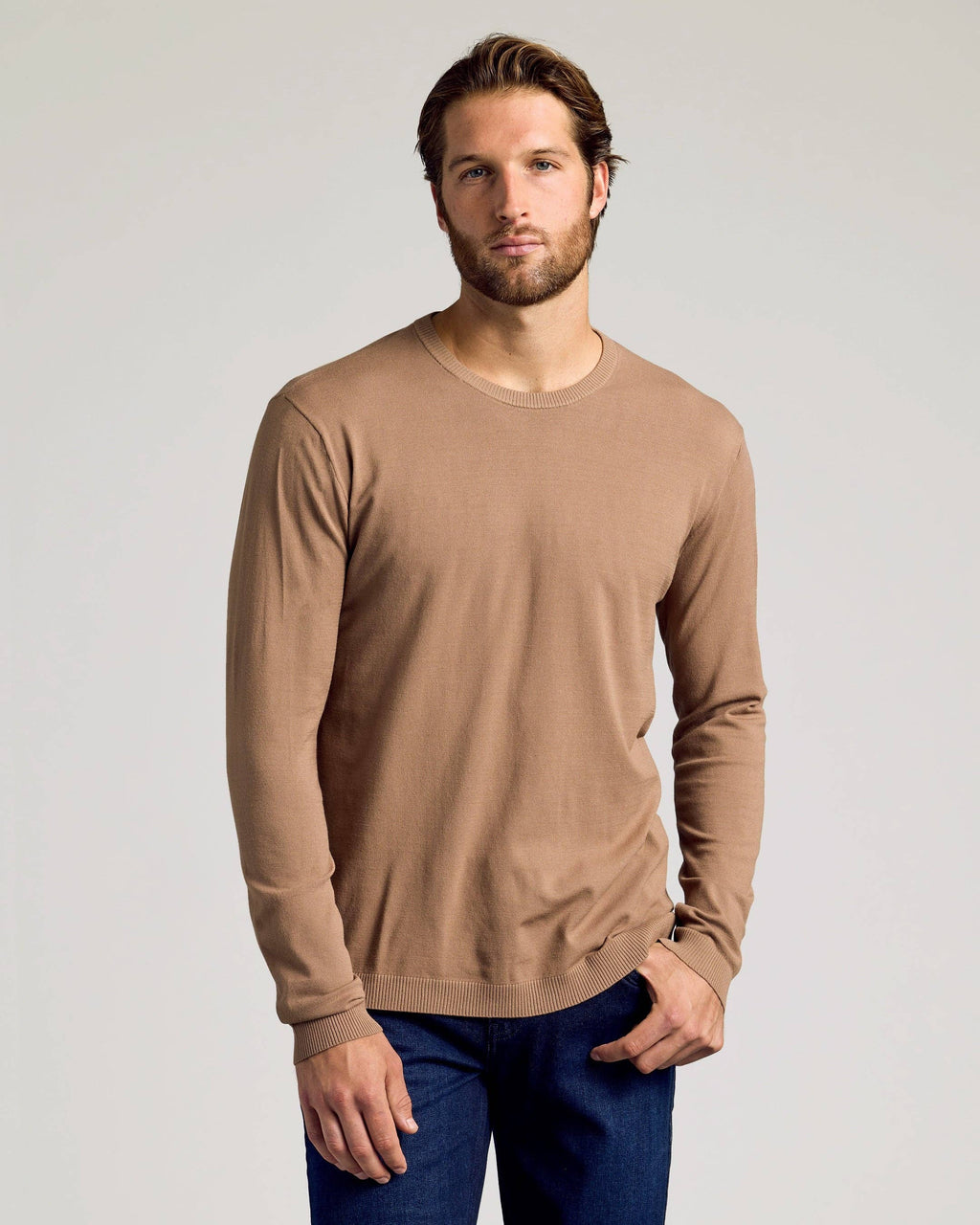 Man wearing a brown long-sleeve shirt against a plain background