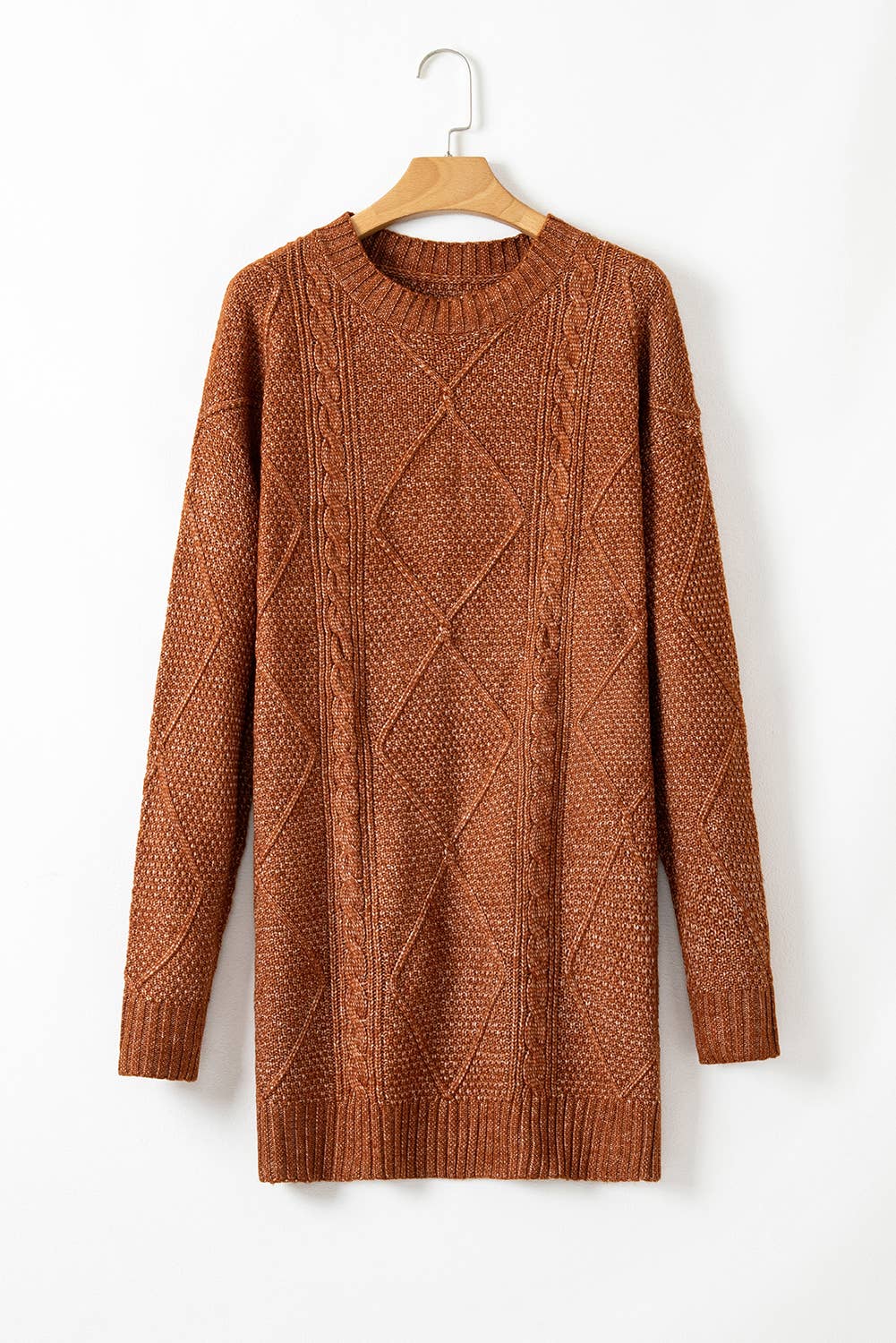 Brown cable knit sweater on a hanger against a white background