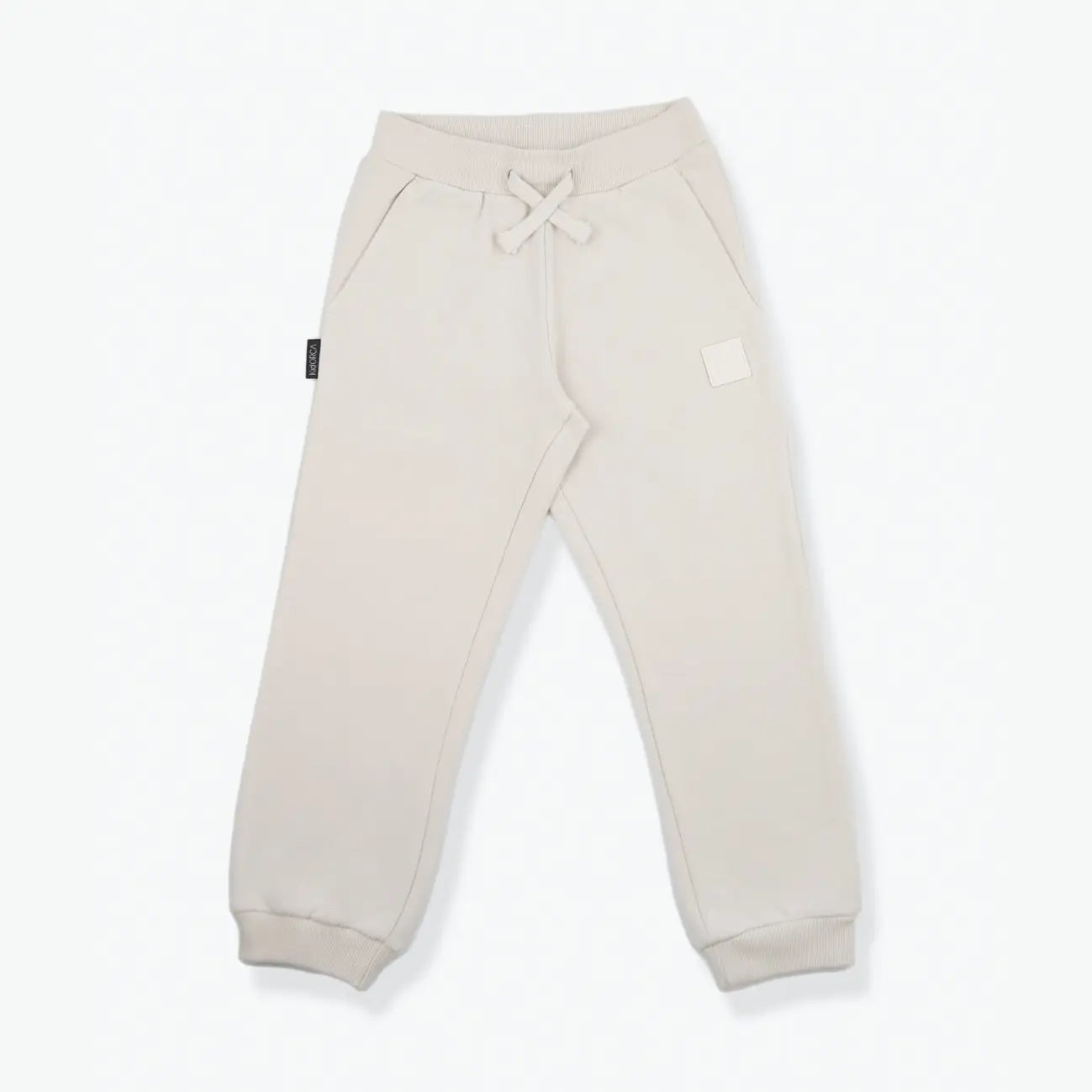 A pair of light beige sweatpants with a drawstring waist and ribbed cuffs, laid flat on a white background.